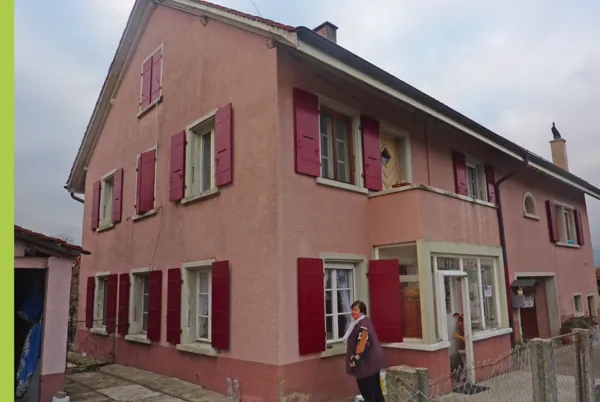 Volets rouges remis en peinture sur une maison rose